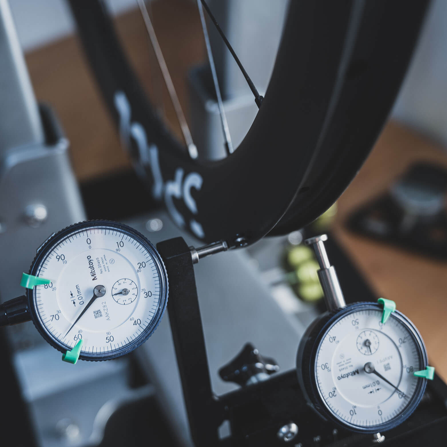 The wheel takes its first spins on a truing stand, now its motion is about to be put in sync.